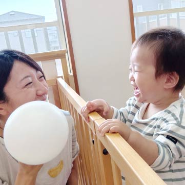 先生と遊んでニコニコ待つ子ども